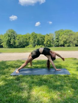 Selin in wild thing pose on a park lawn.